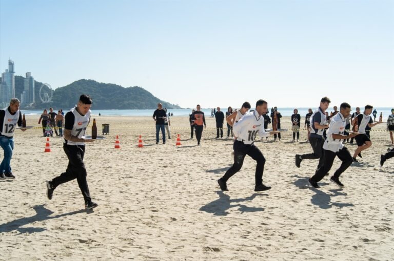 VÍDEO: corrida de garçons reúne mais de 150 profissionais em disputa na praia alargada de Balneário Camboriú